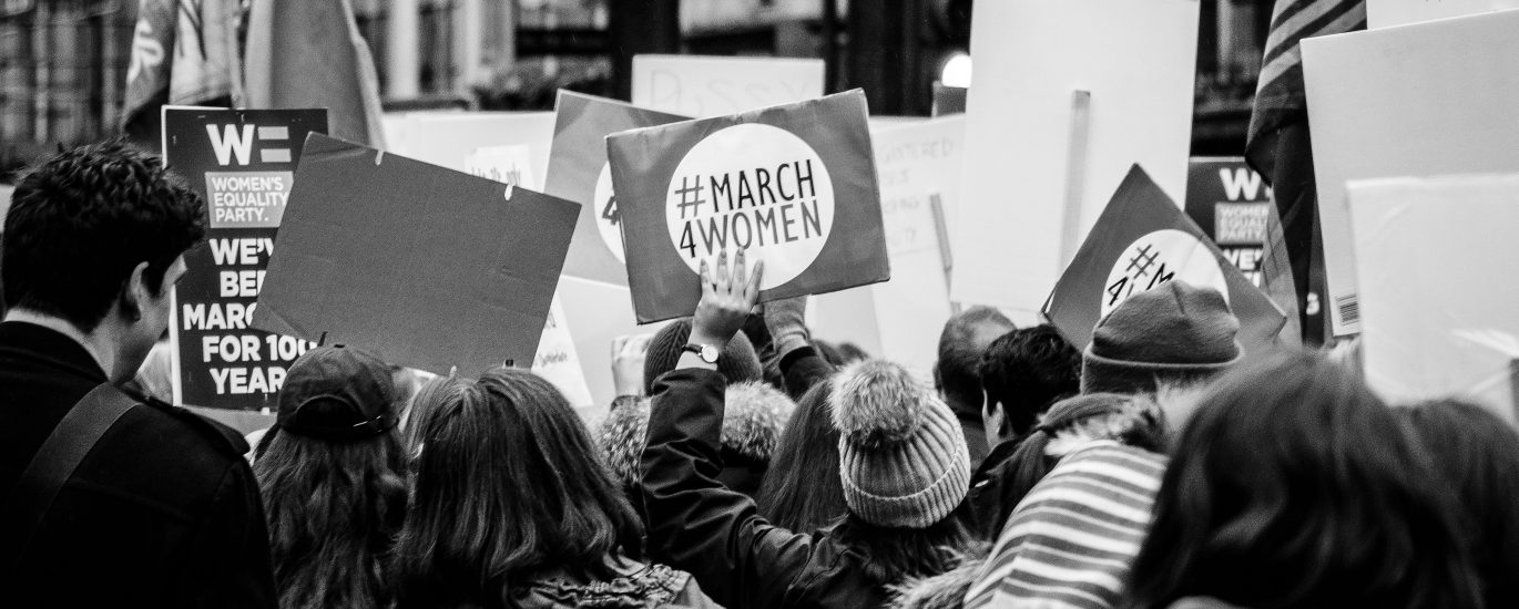 grayscale photo of group of people performing rally on street