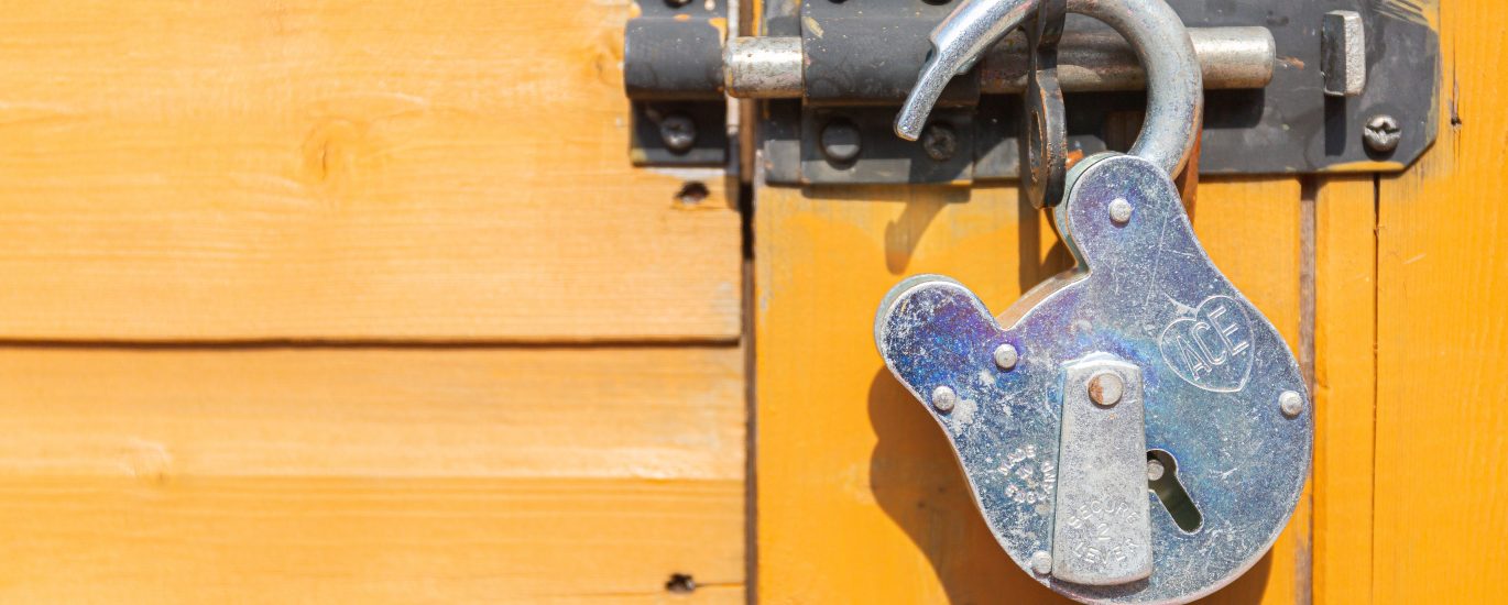 brown wooden door with padlock