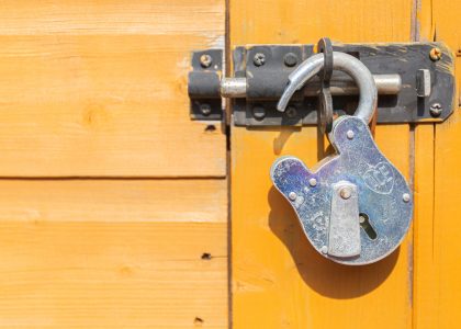 brown wooden door with padlock